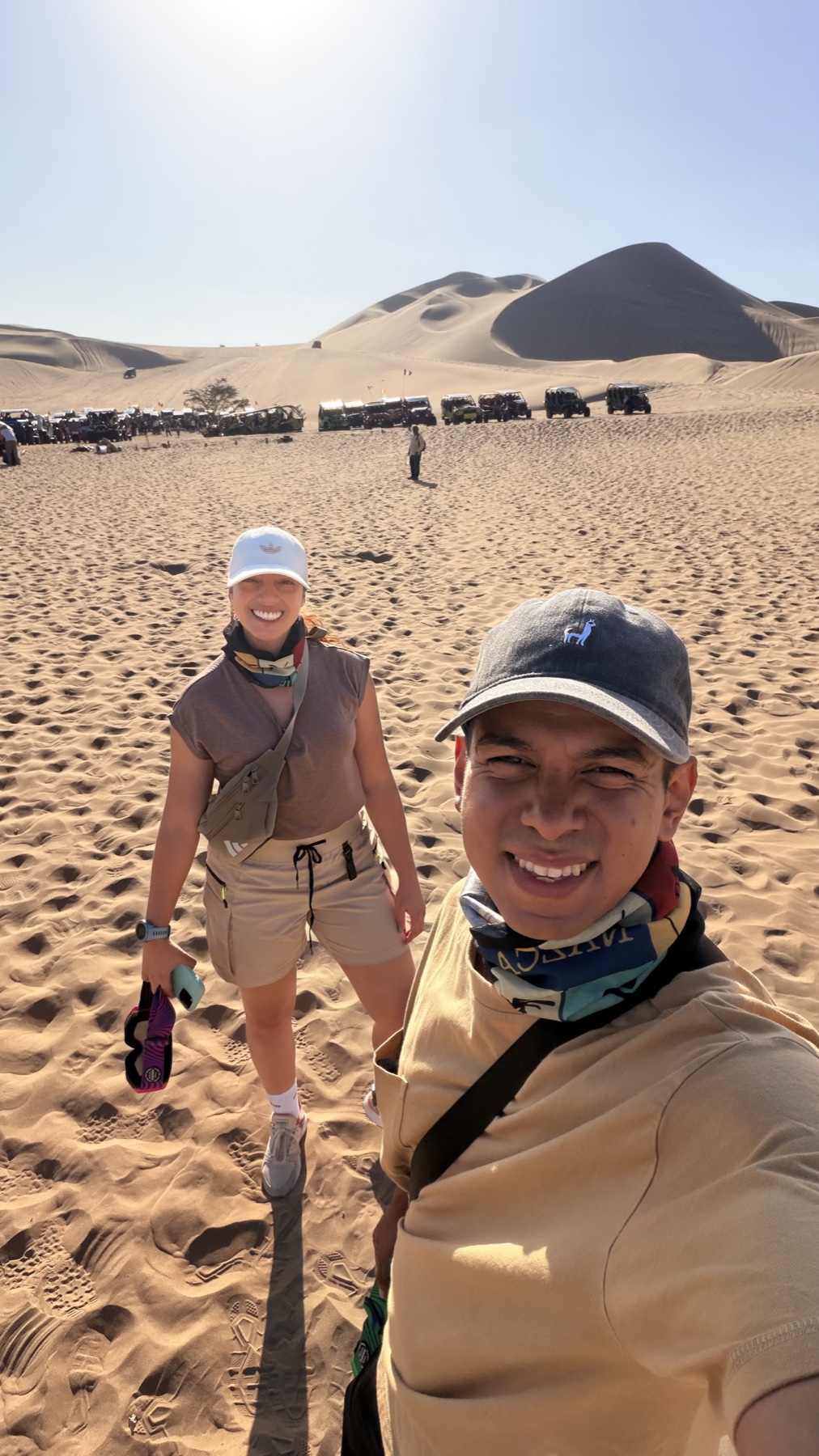 Laura y Lewis sonriendo entre las dunas de Huacachina