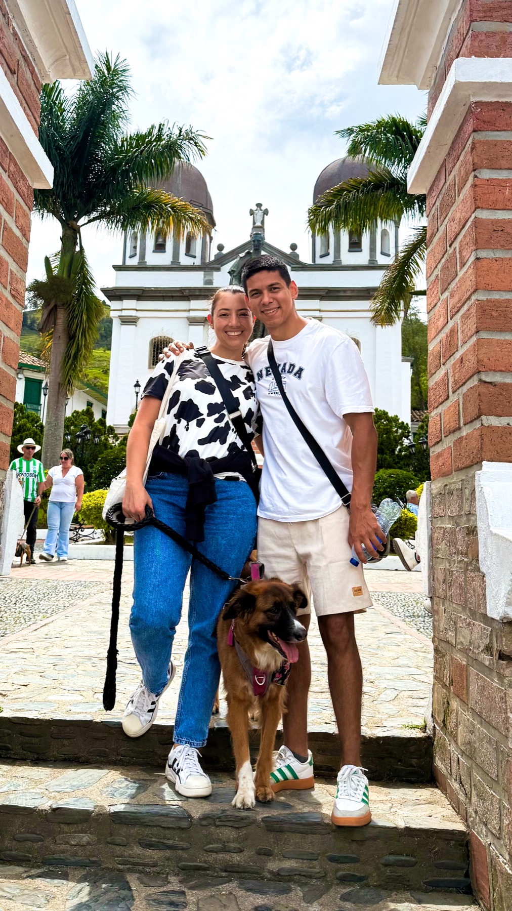 Laura y Lewis con su perro frente a una iglesia