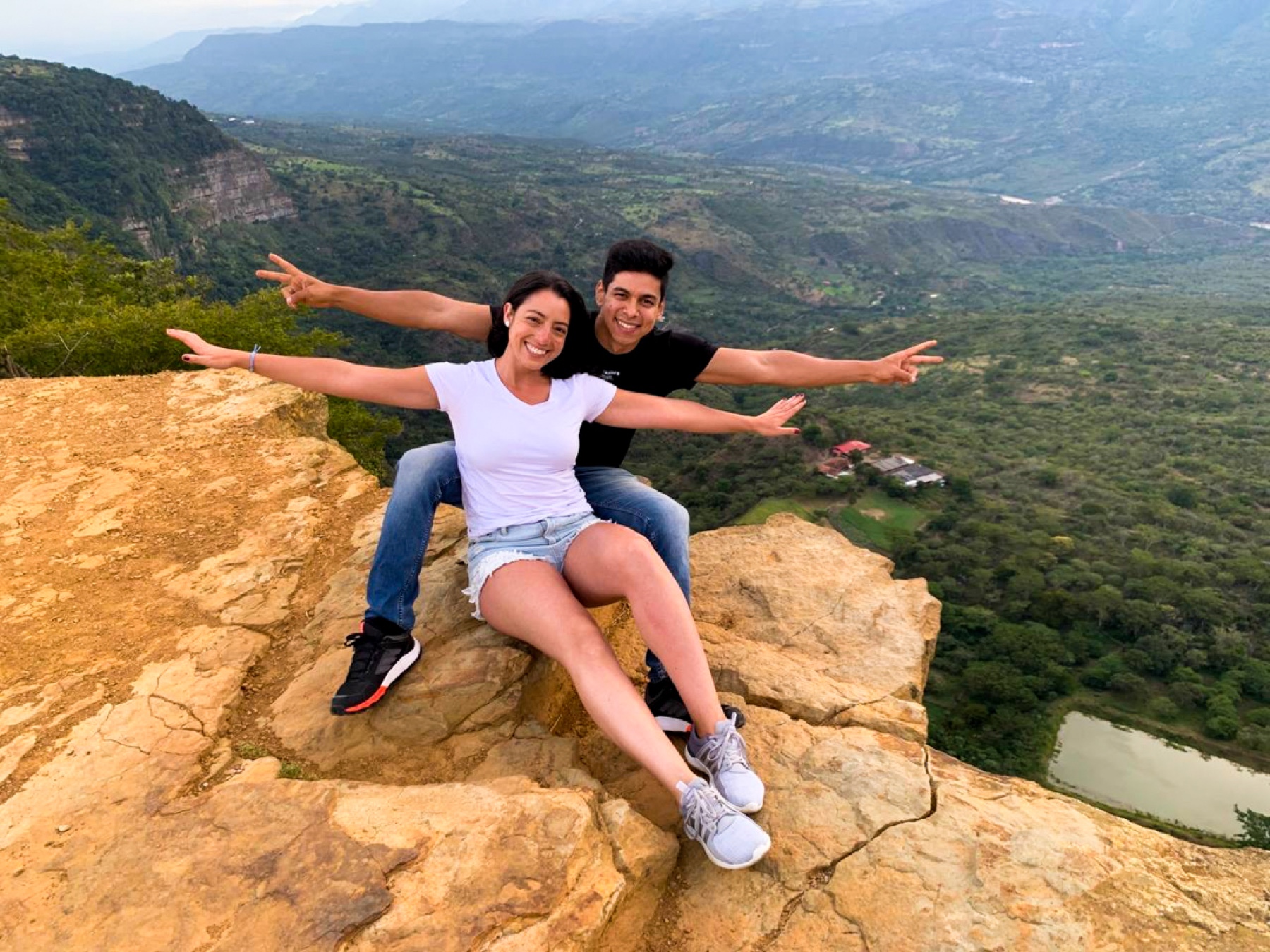 Laura y Lewis sentados en un mirador, con los brazos extendidos sobre el paisaje